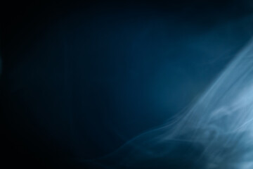 Abstract swirling blue smoke on a dark background, creating a mysterious and ethereal atmosphere. Perfect for artistic, moody, or creative designs.