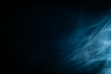 Abstract swirling blue smoke on a dark background, creating a mysterious and ethereal atmosphere. Perfect for artistic, moody, or creative designs.