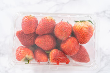 Store-Bought Strawberries in a Plastic Container on the Kitchen Counter