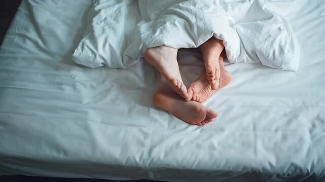 Family couple in bed making love at house, romance woman and man legs togetherness in bedroom. Relationship and intimate of romantic lovers, sexual activity in happy family. naked foot from mattress