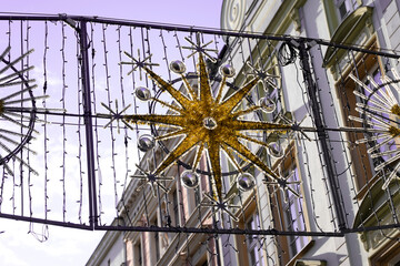 A decorative street installation featuring a golden star surrounded by reflective silver spheres...