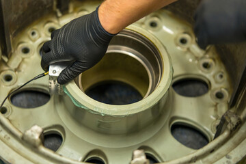 Aircraft Wheel NDT Inspection Using Ultrasonic Testing Equipment. Aviation maintenance technician performs non-destructive testing of landing gear component
