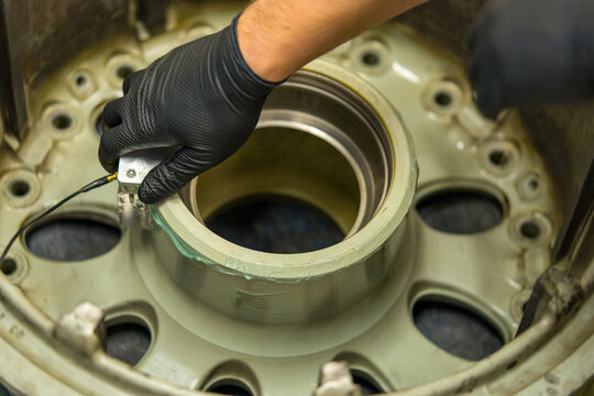 Aircraft Wheel NDT Inspection Using Ultrasonic Testing Equipment. Aviation maintenance technician performs non-destructive testing of landing gear component