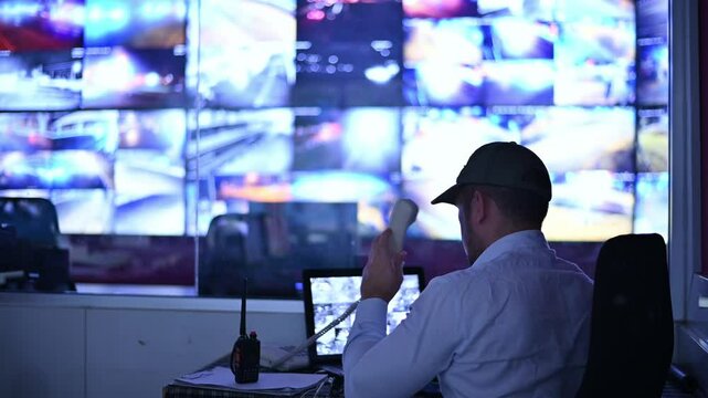 Security guards are monitoring multiple CCTV cameras and answering phone calls.