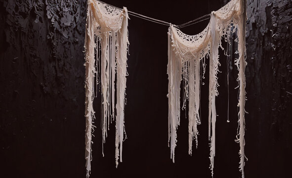 Pair of white strings hanging from the ceiling. The strings are frayed and tangled. The strings are hanging from a black background - Powered by Adobe