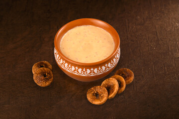 Anjeer rabadi in bowl with anjeer (fig) on brown colour baground 