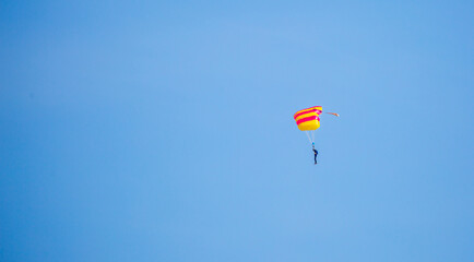 Skydiving. Flying parachutists against the background of the blue sky and mountains. Extreme sport and entertainment.