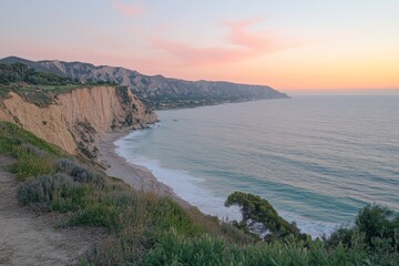 Obraz premium Cliffside view of the ocean with dramatic sunset colors