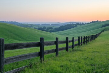 Rolling green hills with wooden fence under soft sunlight