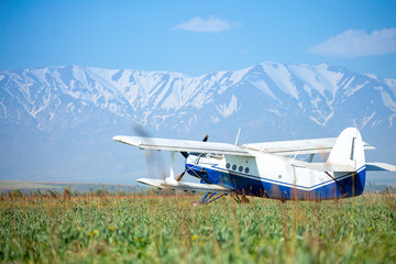 The plane flies over the fields, spraying the fields with insecticides for a good harvest.