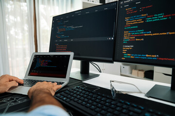 Cropped typing hands photo in IT developer working software development coding on laptop with...
