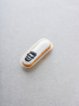 An artisanal dessert sits elegantly on a neutral surface, adorned with a stunning black and white frosting design. This treat highlights fine pastry skills and creativity