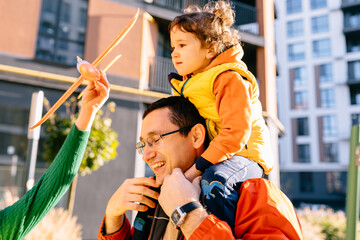 Father and young daughter enjoying outdoor activity with toy airplane