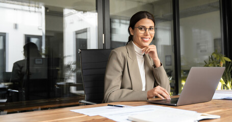 Middle age European business woman CEO using laptop application for work at table workspace in...