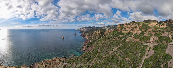 Panoramic view of the historic mining village of Nebida in Sardinia, framed by impressive cliffs and the turquoise-coloured sea, with a view to the north.