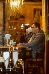 young man in cafe drinking from cup