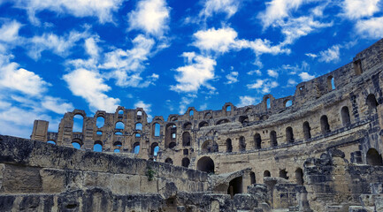 Amphitheater of El Jem in Tunisia with blue sky and clouds..