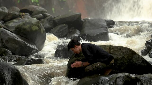 man washing his face in the wild. man alone in the wild and looking alone