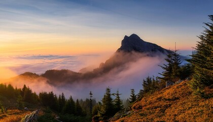 a majestic mountain peak bathed in the golden rays of dawn surrounded by a sea of mist and a lush forest