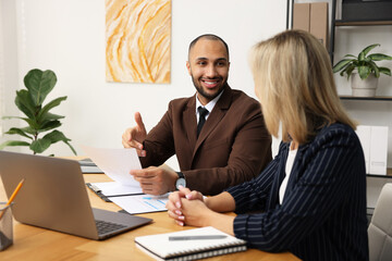 Coworkers working together at table in office