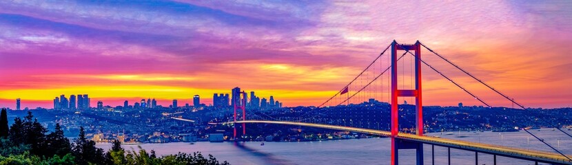 Panoramic view of Istanbul's Bosphorus Bridge at dawn.Breathtaking panoramic view of the Bosphorus Bridge in Istanbul during a vibrant sunrise or sunset. Best touristic destination Turkiye, Turkey