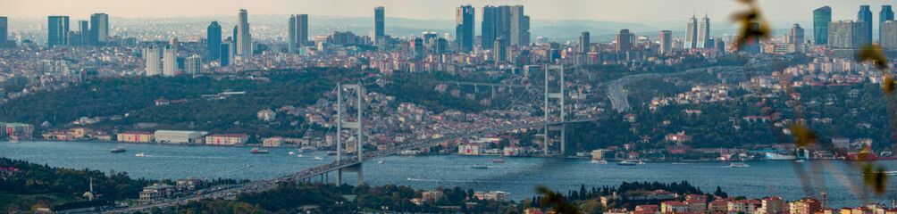 Naklejka premium Panoramic view of Istanbul's skyline and Bosphorus Bridge. High-angle, full shot of Istanbul, Turkey, showcasing the city's urban sprawl, including modern skyscrapers and the Bosphorus Bridge