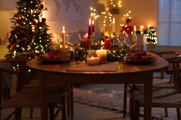 Festive table setting in room decorated for Christmas. Bokeh effect