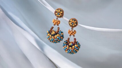 Handcrafted Blue and Yellow Beaded Earrings Displayed on a White Curtain Background