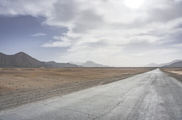 Asphalt road of the Pamir Highway in the valley of the Tien Shan Mountains in Tajikistan in the...