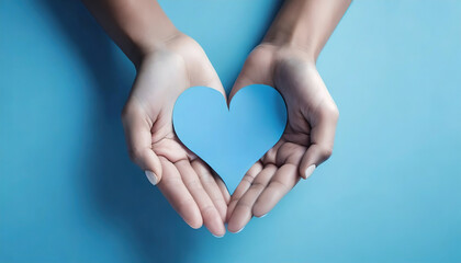 Obraz premium Hands gently holding a blue paper heart symbolizing care and love on smooth backdrop