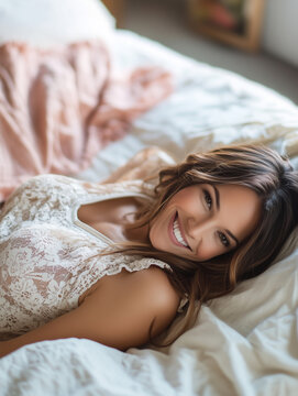 Woman smiling in a cozy bedroom setting, sunlight streaming through the window in the morning