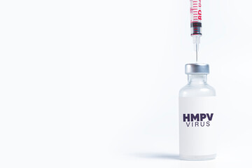 Medical vial labeled HMPV virus with syringe inserted on white background with copy space. Medical concept