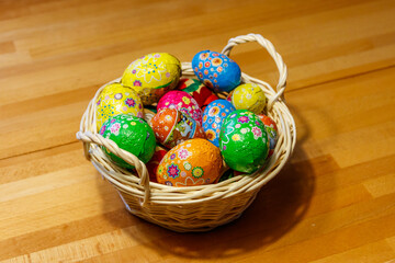 Basket with Easter eggs on wooden table