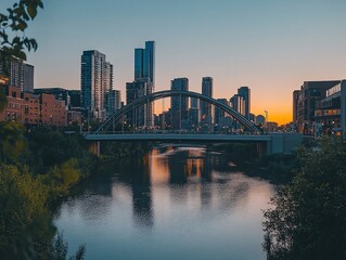Obraz premium Cityscape at sunset, river, bridge, buildings, reflection.