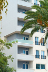 Vertical image modern minimalist apartment buildings in Mediterranean style with palm trees in Albania near the sea coast. Concept of foreign real estate, digital nomads, apartment rental in resort