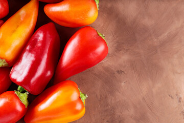 Ripe Red and Orange Capsicum on Brown Background for Vegetarian and Vegan Meals, Copy Space