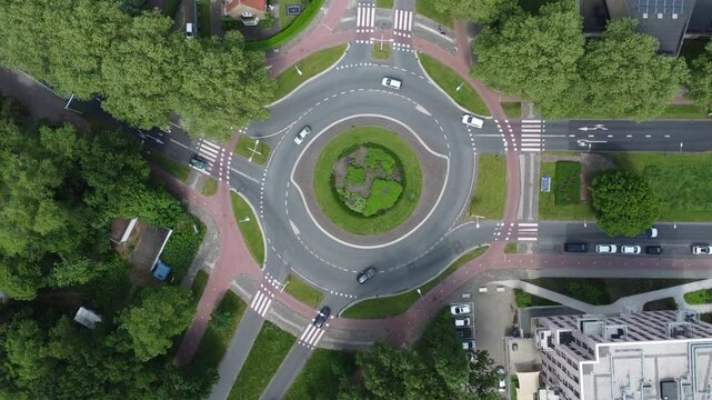 timelapses above a Dutch traffic in Zandlaan roundabout surrounded by lush trees in Ede, Netherlands