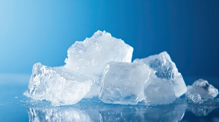 Obraz premium Close-up of several translucent ice cubes on a reflective surface against a blue backdrop.