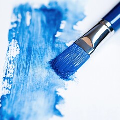 Fototapeta premium a paintbrush with blue paint making a stroke on white paper