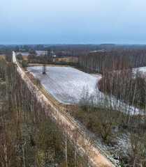 Fototapeta premium A December day in the Latvian countryside in Latgale, a meadow, a country road and Lake Siver can be seen.