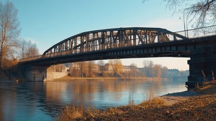 Naklejka premium An elegant bridge spanning over a river, highlighting its architectural features against a clear blue sky.