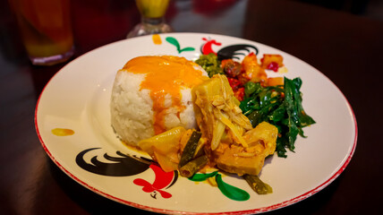 A serving Nasi Padang (Indonesian food) consist of steamed rice with a savory curry sauce, accompanied by vegetables