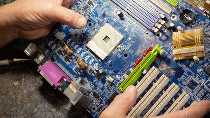 Technician repairing a computer in a workshop. Selective focus.