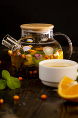 tea with orange and ripe sea buckthorn berries