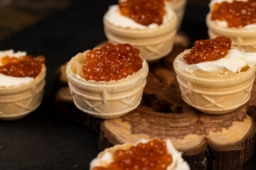 a quick snack from a waffle cup with buttercream and natural red caviar