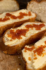 a soft loaf of wheat flour with butter and red salmon caviar