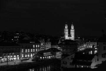 Fototapeta premium Nighttime View of Historic City Center with Illuminated Cathedral and Buildings in Zurich