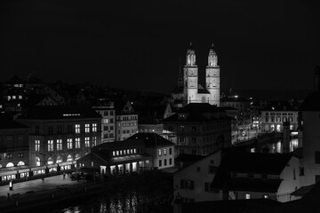 Obraz premium Nighttime View of Historic City Center with Illuminated Cathedral and Buildings in Zurich