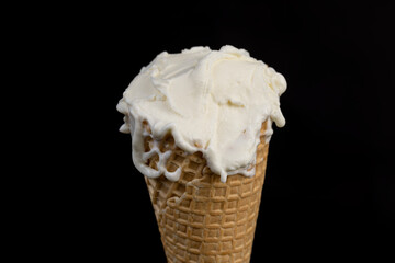 creamy ice cream in a waffle cone on a black background