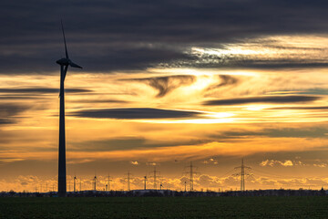 Sonnenuntergang &uuml;ber einem Windpark in Ostdeutschland, mit einem dramatischen Himmel aus dichten Wolken 